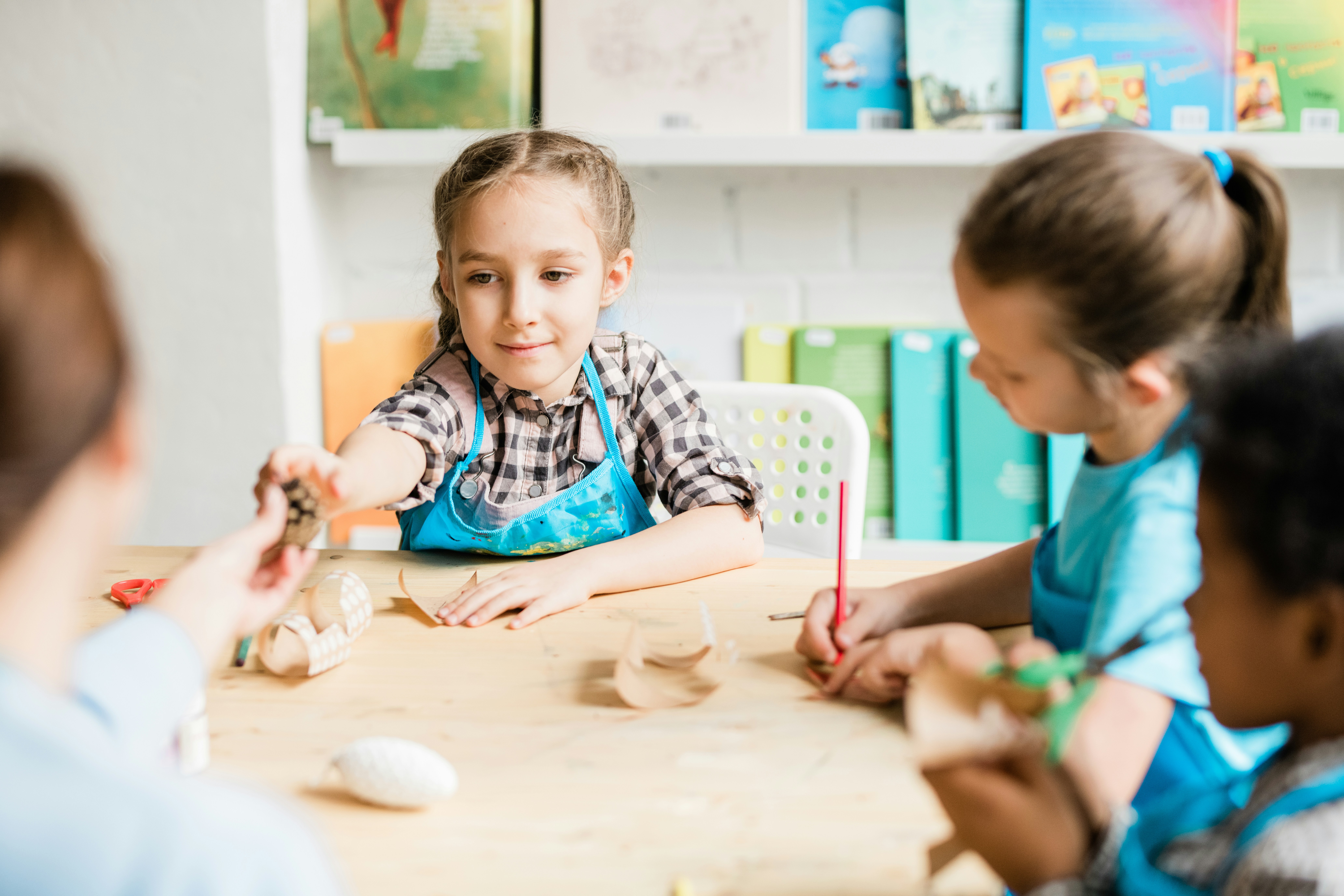 A child practicing writing letters in a bright, sunny classroom